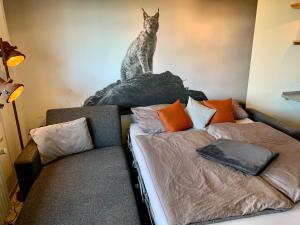 ein Schlafzimmer mit einem Bett und einer Katzenstatue an der Wand in der Unterkunft Luchsbutze in Sankt Andreasberg