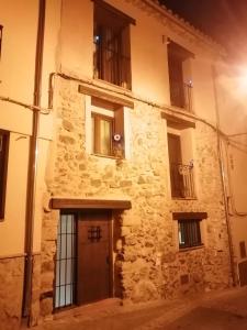 um antigo edifício de pedra com uma porta e janelas em Cuatro Rosas Jerica em Jérica