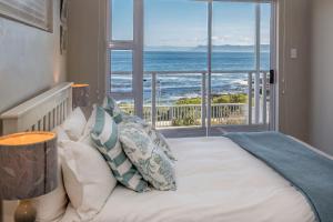 a bedroom with a bed with a view of the ocean at Ons C-Huis - Gansbaai Seafront Accommodation, back-up power in Gansbaai