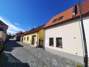 a cobblestone street next to a white and yellow building at Apartmán Blatná in Blatná