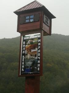 uma torre de madeira com um sinal em cima em Vila Djekic em Andrijevica