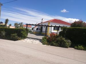 een wit huis met een rood dak en een oprit bij Casas da Lagoa in Santo Isidoro