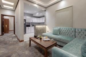 a living room with a blue couch and a table at Verdun Suites in Al Madinah