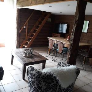een woonkamer met een trap en een tafel en stoelen bij Rimbes Casteljaloux - gite 6 pers Rustique in Casteljaloux