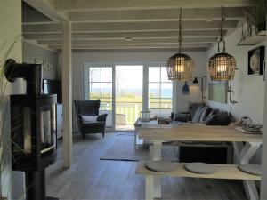 uma sala de estar com uma mesa e uma lareira em Ferienhaus Oceanview em Sierksdorf