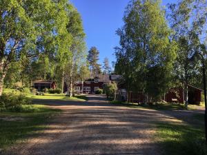 a road in front of a house with trees at Purola Farm Guesthouse in Saarij&auml;rvi