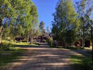 a road in front of a house with trees at Purola Farm Guesthouse in Saarijärvi