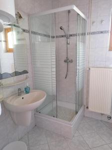 y baño con ducha y lavamanos. en Vica Apartman, en Balatonberény