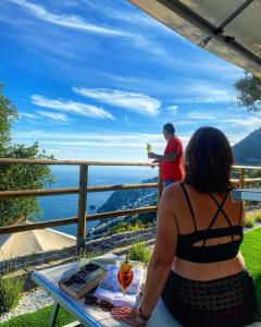 un homme et une femme assis à une table avec un verre dans l'établissement Villa Cimea, à Furore