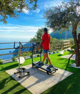 a person walking on a exercise bike near the ocean at Villa Cimea in Furore