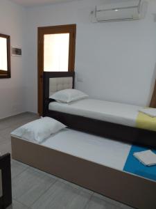 two twin beds in a room with a window at Grand Seaview Apartments in Ksamil