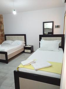 a bedroom with two beds and a mirror on the wall at Grand Seaview Apartments in Ksamil
