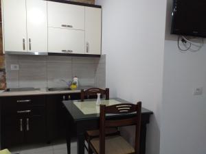a kitchen with a table and chairs and a sink at Grand Seaview Apartments in Ksamil