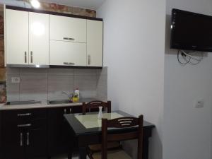 a kitchen with a table and chairs and a tv at Grand Seaview Apartments in Ksamil