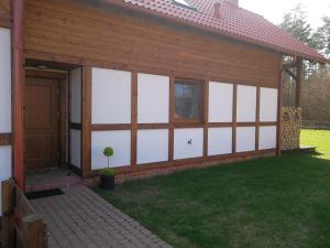 a garage with white panels on the side of a house at Leśna Ostoja in Borowy Młyn