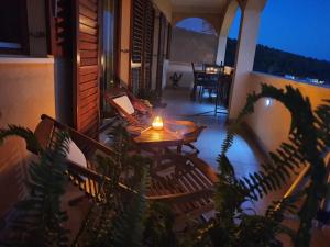 a patio with a table and chairs on a balcony at night at Apartment Ivana in Trogir