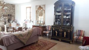 una sala de estar con un armario de porcelana y un sofá en chez céline en Sens-de-Bretagne