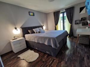 1 dormitorio con 1 cama grande y escritorio en Apartman Lejla, en Poreč