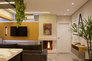 een woonkamer met een open haard en een televisie bij Incrível apartamento no Centro de Gramado in Gramado