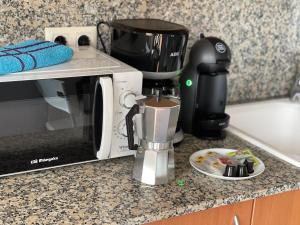 a coffee maker on a counter next to a microwave at SeaHomes Vacations, FENALS BEACH&CHIC, pk, top apartment full equipped in Lloret de Mar