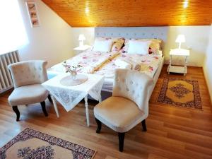 a bedroom with a bed with a table and two chairs at Elisoria Apartments in Cserszegtomaj