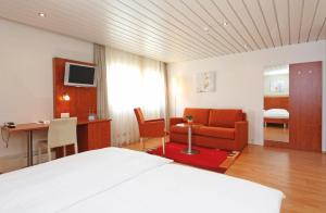 a hotel room with a bed and a desk at Aarauerhof - Self Check-in in Aarau