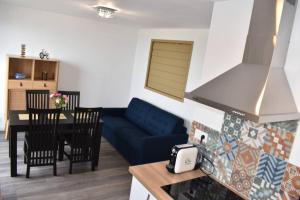 ein Wohnzimmer mit einem blauen Sofa und einem Tisch in der Unterkunft Confort et calme au sud de Bastia in Bastia