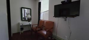 a living room with a television and a chair at Cosmopolitan Hotel in Blairmore