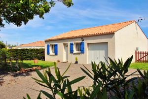 ein kleines weißes Haus mit blauen Fenstern und einem Hof in der Unterkunft Maison de vacances à 10min des plages et de la Tranche sur Mer in La Jonchère