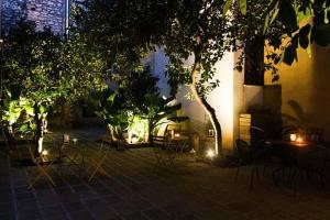 a patio with chairs and tables at night with lights at B&B MAMAOH in Fondi