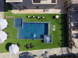 卡特羅斯的住宿－Orion Eco Suites，享有游泳池和带遮阳伞的草坪的顶部景致