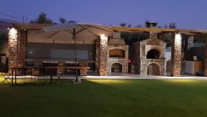 an outdoor patio with a table and an umbrella at Orion Eco Suites in Karteros