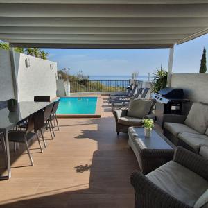 a patio with a table and chairs and a pool at Niza Beach in Málaga