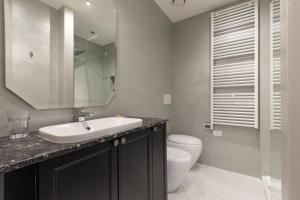 a bathroom with a sink and a toilet and a mirror at Missori Suites in Milan