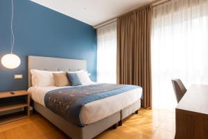 a bedroom with a bed and a blue wall at Missori Suites in Milan