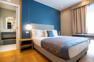 a bedroom with a large bed with a blue wall at Missori Suites in Milan
