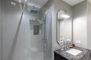 a bathroom with a shower and a sink and a mirror at Missori Suites in Milan