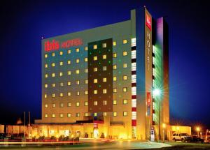 a building with arets hotel at night at Ibis Juarez Consulado in Ciudad Juárez