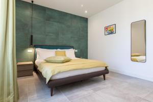 a bedroom with a bed with a green wall at Missori Suites in Milan