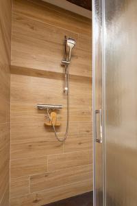 a shower in a bathroom with a wooden wall at NINA VENICE APARTMENT in Venice