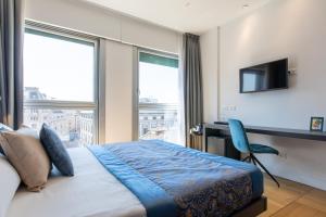 a bedroom with a bed and a desk and a television at Missori Suites in Milan