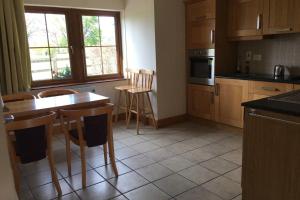 a kitchen with wooden cabinets and a table and chairs at Your very own 19th hole!! in Tipperary