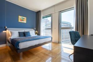a bedroom with a bed with blue walls and a desk at Missori Suites in Milan