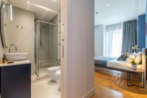 a bathroom with a bed and a toilet and a sink at Missori Suites in Milan