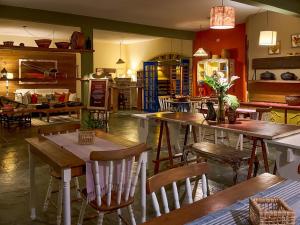 un restaurante con mesas y sillas en una habitación en Sollar dos Gerânios, en Peruíbe