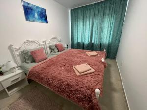 a bedroom with a white bed with a red blanket at Castle Residence apt. Zamorei in Buşteni