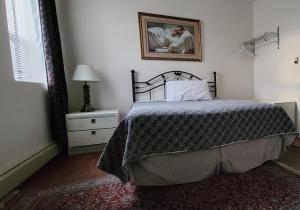 a bedroom with a bed and a lamp at Cosmopolitan Hotel in Blairmore
