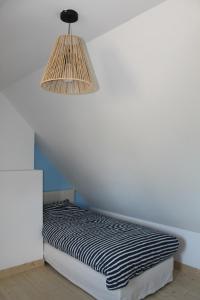 łóżko w pokoju z lampką na ścianie w obiekcie Maison Belle-Ile en Mer w mieście Bangor