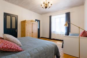 a bedroom with a bed and a chandelier at Karlamuiza Country Hotel in Kārļi