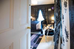 a hallway with a bedroom with a bed and a chair at Bruckless Rest - Fine Country Living in Milltown